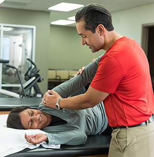 Physical therapist working with woman on arm stretches.